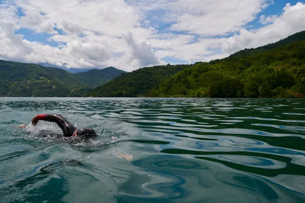 Atleta de triatlón nadando en el lago con traje de neopreno —  Fotos de Stock