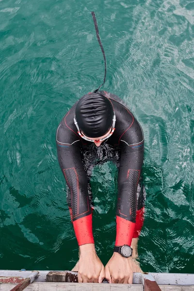 Triatlon atleet zwemmen op meer dragen wetsuit — Stockfoto