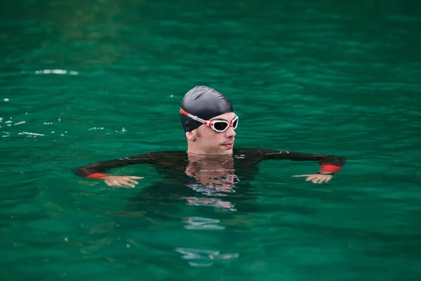 Atleta de triatlón nadando en el lago con traje de neopreno — Foto de Stock
