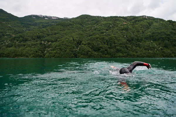 Atleta de triatlón nadando en el lago con traje de neopreno —  Fotos de Stock