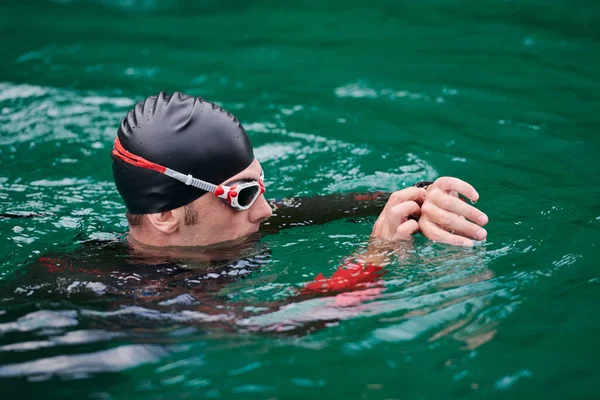Triathlet schwimmt auf Smartwatch im See — Stockfoto