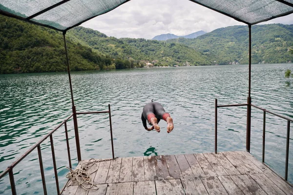 Тріатлон спортсмен стрибає у воду і починаючи з тренувань — стокове фото