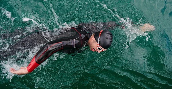 Triatlon atléta úszás a tavon búvárruhában — Stock Fotó