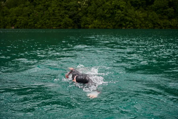 トライアスロン選手がウェットスーツを着て湖を泳ぎ — ストック写真