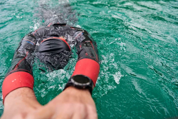 Triatlon atleet zwemmen op meer dragen wetsuit — Stockfoto