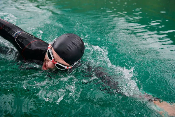 Atleta de triatlón nadando en el lago con traje de neopreno —  Fotos de Stock