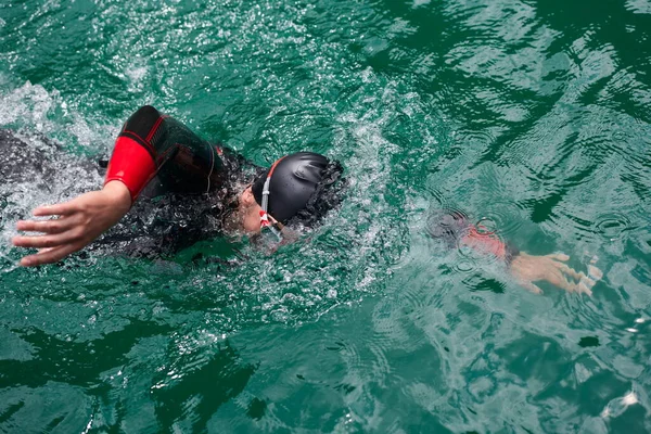 Atleta triatlo nadando no lago vestindo roupa de mergulho — Fotografia de Stock