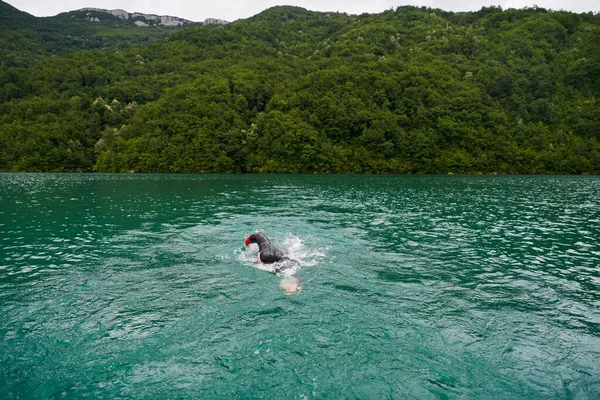 トライアスロン選手がウェットスーツを着て湖を泳ぎ — ストック写真