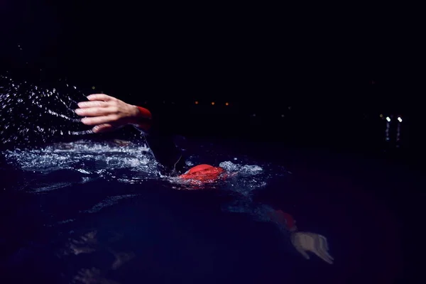 Atleta de triatlón nadando en la noche oscura usando traje de neopreno —  Fotos de Stock