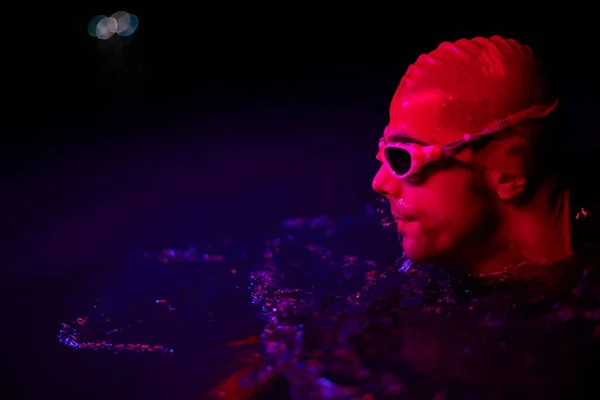 Auténtico nadador de triatleta teniendo un descanso durante el entrenamiento duro en la noche luz de gel de neón —  Fotos de Stock