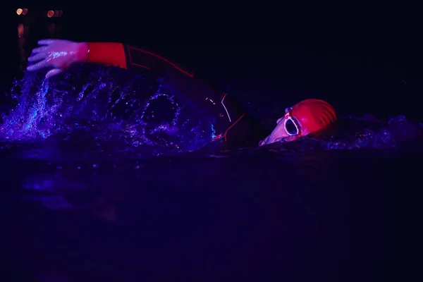 Vero atleta di triathlon che nuota nella notte buia — Foto Stock