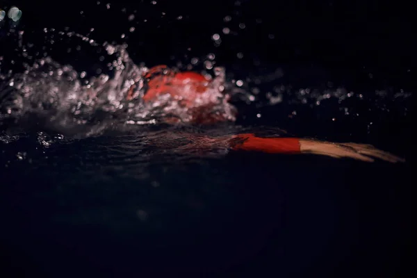 Triathlon idrottare simma i mörk natt bär våtdräkt — Stockfoto