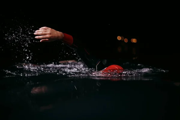 Atleta de triatlón nadando en la noche oscura usando traje de neopreno —  Fotos de Stock