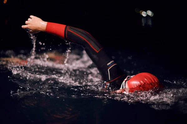 Triathlet schwimmt in dunkler Nacht im Neoprenanzug — Stockfoto