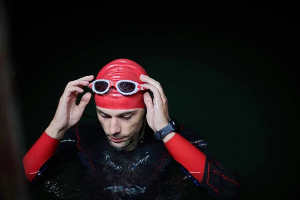 Authentic triathlete swimmer having a break during hard training on night — Stock Photo, Image