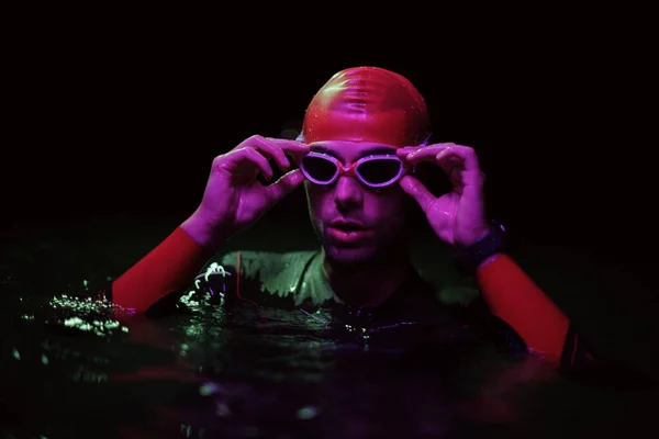 Auténtico nadador de triatleta teniendo un descanso durante el entrenamiento duro en la noche luz de gel de neón —  Fotos de Stock