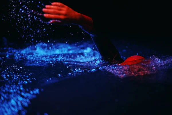 Atleta de triatlón real nadando en la noche oscura — Foto de Stock