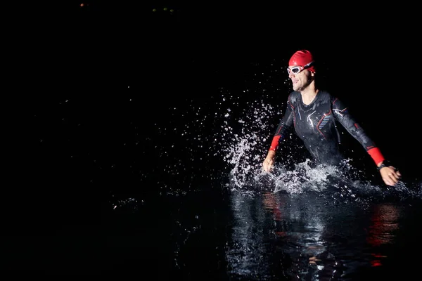 Triatlón atleta terminar el entrenamiento de natación en la noche oscura —  Fotos de Stock