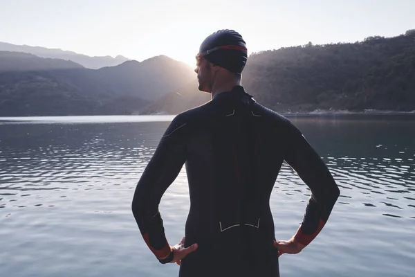 triathlon athlete starting swimming training on lake