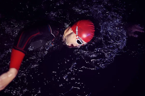 real triathlon athlete swimming in dark night