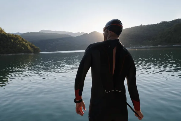 Atleta di triathlon iniziare l'allenamento di nuoto sul lago — Foto Stock