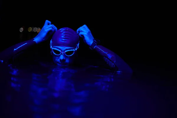 真正的游泳运动员在夜间霓虹灯的强化训练中休息一下 — 图库照片