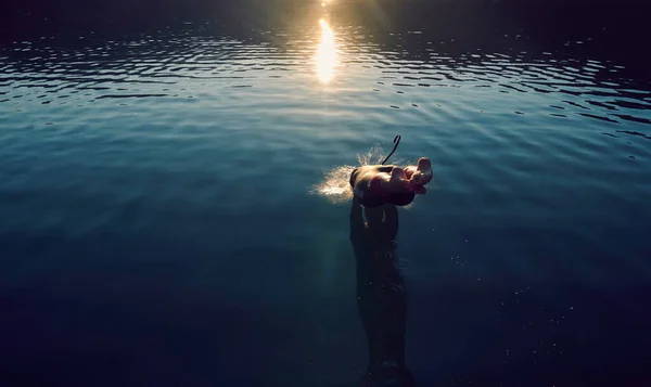 Triathlon athlete jumping in to water and starting with training — Stock Photo, Image