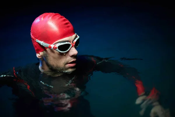 Autêntico triatleta nadador tendo uma pausa durante o treinamento duro na noite — Fotografia de Stock