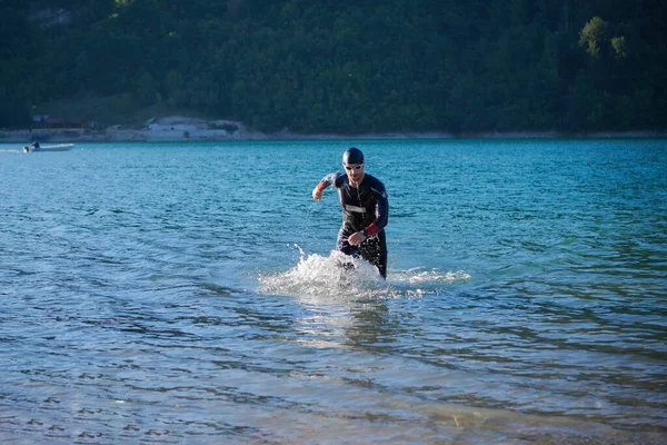 Atleta di triathlon iniziare l'allenamento di nuoto sul lago — Foto Stock