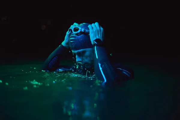 Auténtico nadador de triatleta teniendo un descanso durante el entrenamiento duro en la noche luz de gel de neón —  Fotos de Stock