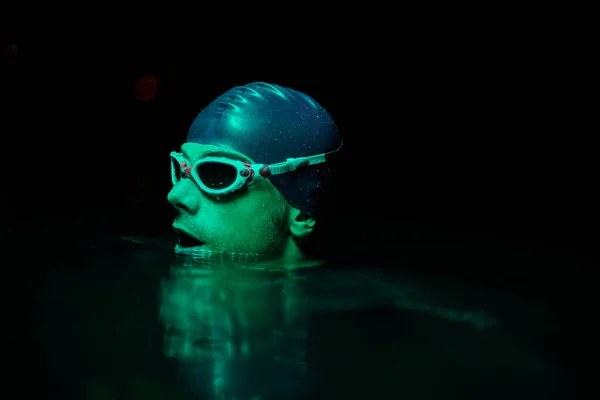 Auténtico nadador de triatleta teniendo un descanso durante el entrenamiento duro en la noche luz de gel de neón — Foto de Stock