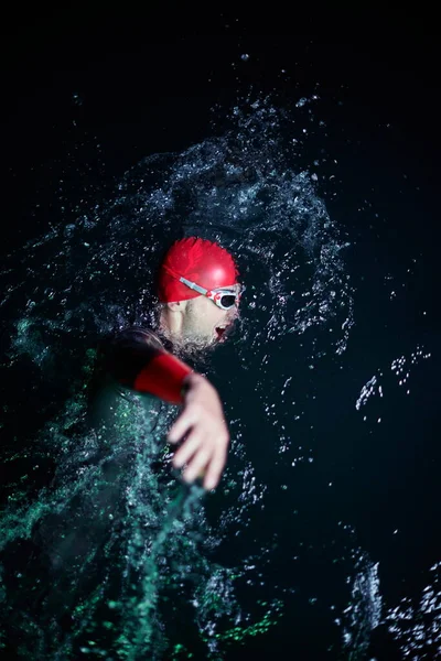 어두운 밤에 수영하는 3 종 경기 선수 — 스톡 사진