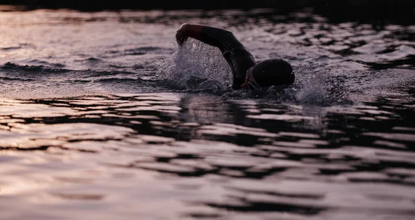 새벽에 잠수복을 입고 호수에서 수영하는 3 종 경기 선수 — 스톡 사진