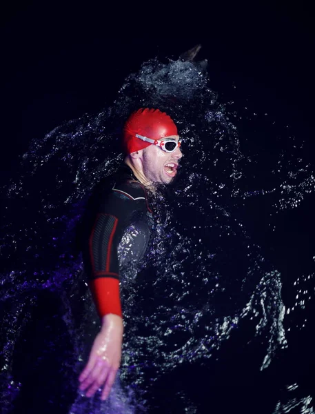 Atleta de triatlón real nadando en la noche oscura —  Fotos de Stock