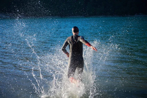 Atleta de triatlón comenzando a nadar entrenamiento en el lago —  Fotos de Stock