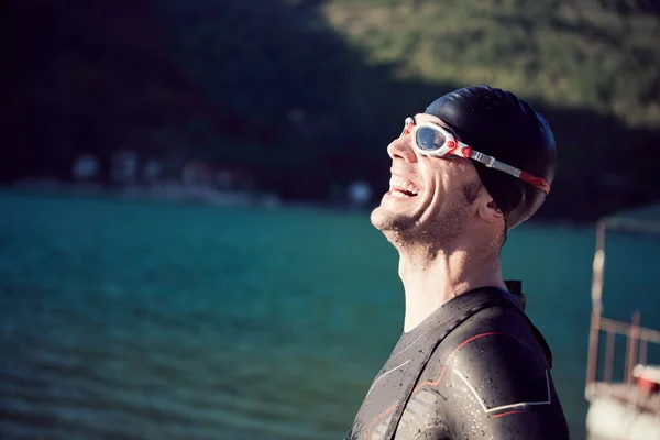 triathlon athlete starting swimming training on lake