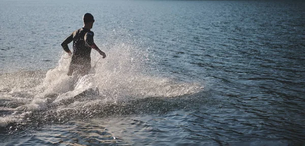 Triatlon sportovec začíná plavání trénink na jezeře — Stock fotografie