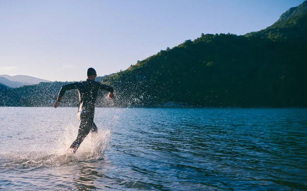 Atleta de triatlón comenzando a nadar entrenamiento en el lago —  Fotos de Stock