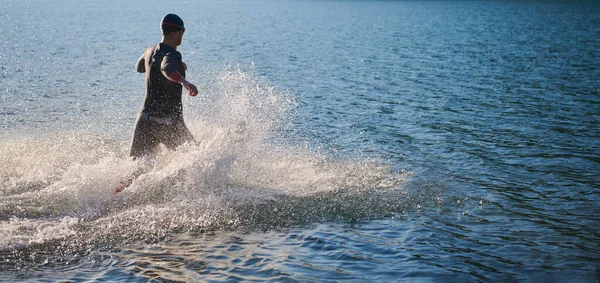 Atleta di triathlon iniziare l'allenamento di nuoto sul lago — Foto Stock