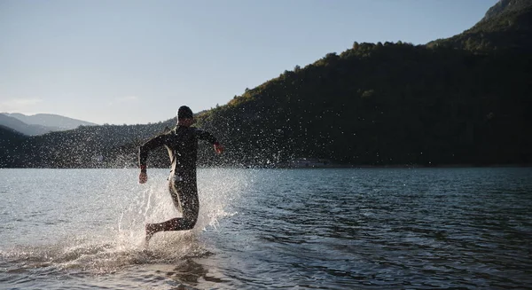 Triathlon athlete starting swimming training on lake — Stock Photo, Image