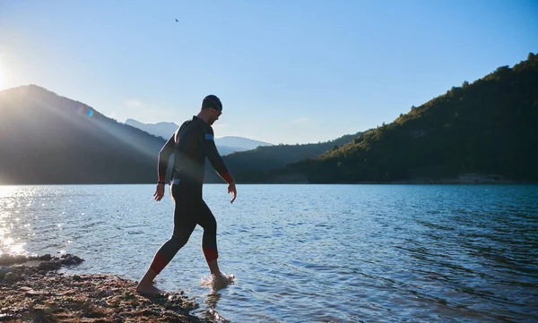 Atleta di triathlon iniziare l'allenamento di nuoto sul lago — Foto Stock