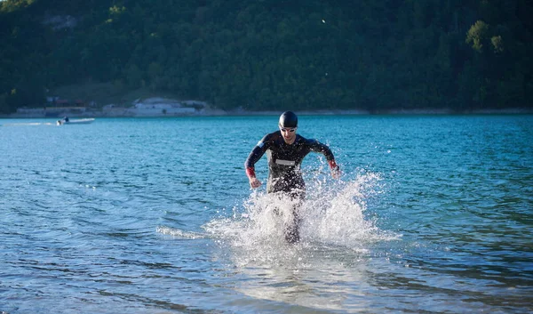 Triatlonista rozpoczynający trening pływacki nad jeziorem — Zdjęcie stockowe