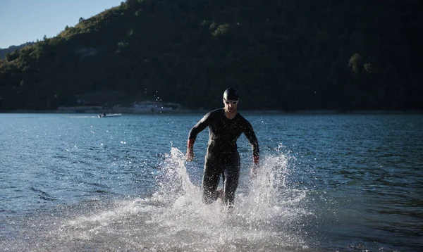 Triatlon sportovec začíná plavání trénink na jezeře — Stock fotografie