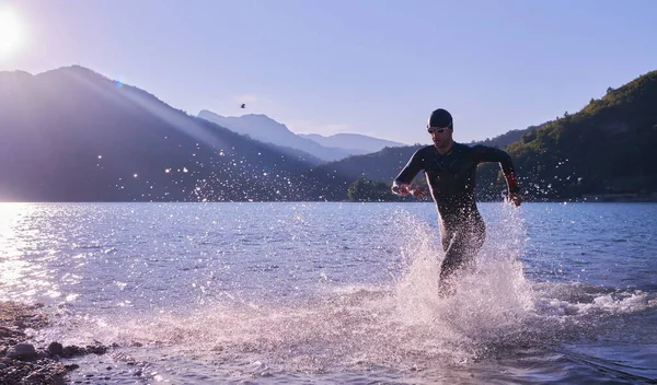 Triatlon sportovec začíná plavání trénink na jezeře — Stock fotografie