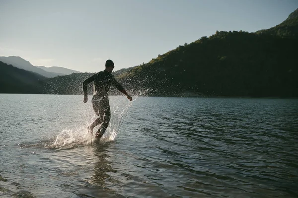 Atleta de triatlón comenzando a nadar entrenamiento en el lago —  Fotos de Stock