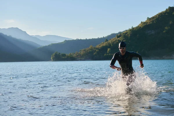 Triathlon athlete starting swimming training on lake — Stock Photo, Image