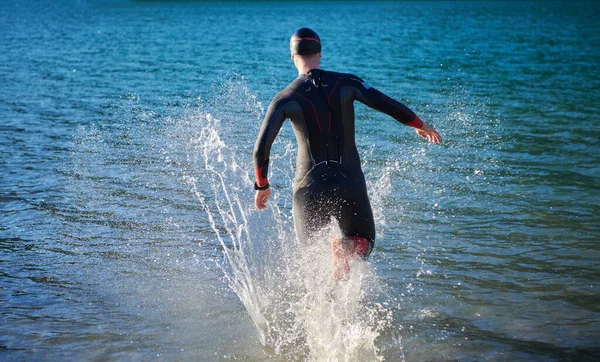 Atleta di triathlon iniziare l'allenamento di nuoto sul lago — Foto Stock