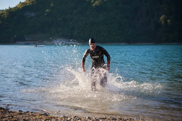 Triathlon athlete starting swimming training on lake — Stock Photo, Image