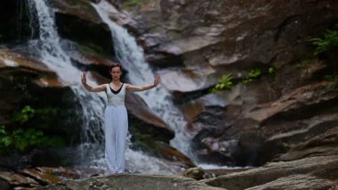 Gün batımında şelale ve nehir kenarında ağır ağır tai chi hareketleri yapan güzel genç bir kadın doğadaki uyum dengesini ve uygunluğu yakalıyor. Yavaş çekim sinematik çekim