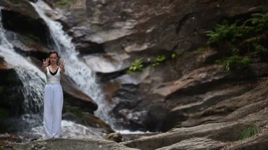 Gün batımında şelale ve nehir kenarında ağır ağır tai chi hareketleri yapan güzel genç bir kadın doğadaki uyum dengesini ve uygunluğu yakalıyor. Yavaş çekim sinematik çekim